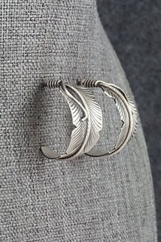 These brushed-finish sterling silver feather-shaped earrings were made by Navajo silversmith Chris Charley. The backs are signed CC and Sterling.Length: 7/8"Width: 1/2"Free shipping on all orders! We ship with USPS and always include tracking. All orders ship within a day of payment.Returns are accepted up to 30 days after you receive your order. Just send us a message. Our shop offers cash back or store credit. The item must be returned in new condition. Adjustable Silver Feather Earrings, Adjustable Silver Earrings With Feathers, Silver Bohemian Feather Earrings, Bohemian Silver Feather Earrings, Silver Feather, Sterling Silver Earrings, Feathers, Silver Earrings, Sterling Silver