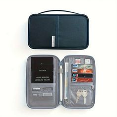 an open case with keys and other items in it on a white surface next to a wallet