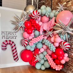 the balloon wall is decorated with balloons and candy canes