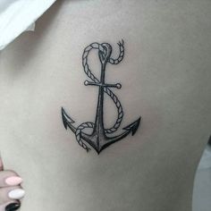 an anchor tattoo on the back of a woman's stomach