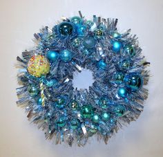 a blue and silver christmas wreath hanging on a wall