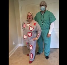 two people in scrubs standing next to each other wearing masks and bodysuits