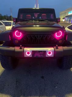 the front end of a jeep with pink lights on it's hood and bumper