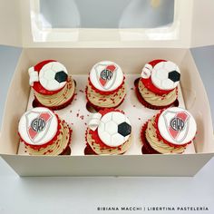 six cupcakes in a box with soccer balls on them