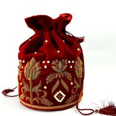 "Look your best wearing this luxurious black velvet pouch bag, exquisitely embroidered with glittery metallic red threads and genuine semi precious stones. It is certain to bring you compliments. Perfect color for Indian wedding! Expertly hand embroidered by third generation master zardozi artisans. Of heirloom quality. - Measures approx 9\" tall, base is 6\" across. - Useable interior space is 6\" x 6 \". - Rigid bottom and 2\" base, so bag sits nicely. - Wrist cord with tassel, 6 in. drop - Ad Luxury Red Bucket Bag With Removable Pouch, Beaded Pouch Bag, Wrist Purse, Velvet Handbag, Hand Embroidered Jewelry, Embellished Purses, Purse Sewing, Beaded Pouch, Purse Sewing Patterns