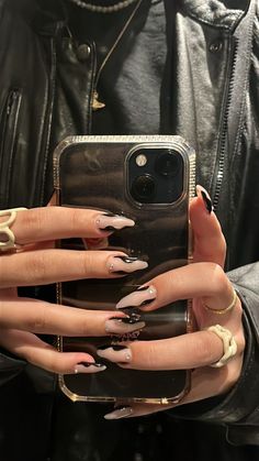 a woman holding up her phone case with some nails on it and one hand in the other