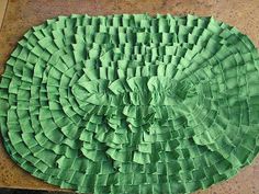 a green piece of paper that has been cut into squares and placed on the floor