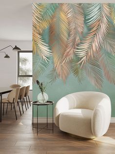 a chair and table in front of a wall with palm leaves painted on the walls