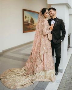 a man and woman standing next to each other in front of a painting on the wall