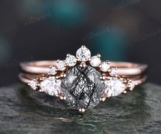 an engagement ring with two pear shaped diamonds on top of it, set in 18k rose gold