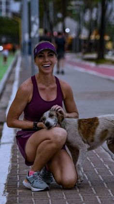 a woman kneeling down next to a dog