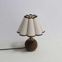 a lamp that is sitting on top of a white table next to a black cord