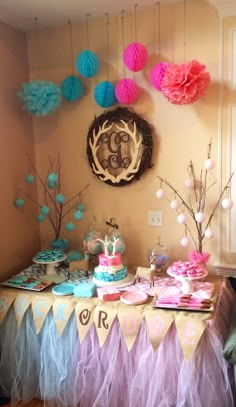 a table topped with cake and cupcakes next to a wall