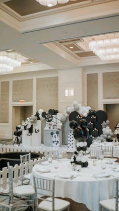 the tables are set up with white and black balloons, mickey mouse head centerpieces, and other decorations