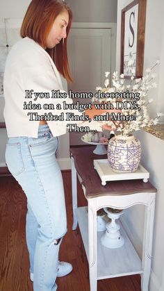 a woman standing in front of a table with flowers on it and a quote above her that reads, if won the home decorating idea can bindet with idyly