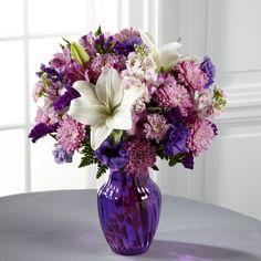 a purple vase filled with white and purple flowers