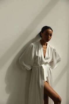 Our long bridal silk robe with wide long sleeves. It could be made of satin or pure mulberry silk. The robe is both casual and elegant, you may wear it on the hen party or spontaneously around your home on a daily basis. It is also an amazing outfit for your vocation, to wear it on the beautiful beach or by the pool as a cover up. -Our model wears size XS, her measurements are 82/61/87 cm and she is 172 cm tall. -Attached with belt. -Arrives beautifully packaged in tissue paper with ribbon -Leng White V-neck Robe For Sleep, Satin V-neck Robe For Daywear, Elegant V-neck Kimono For Daywear, Feminine Wedding Robe With Kimono Sleeves, Chic Silk Robe For Sleeping, Elegant Open Front Kimono For Wedding, Elegant Silk Summer Robe, Elegant Summer Silk Robe, Elegant Long Sleeve Summer Robe