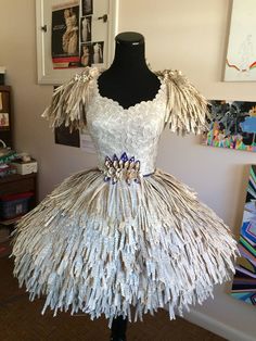 a dress made out of newspaper strips on a mannequin