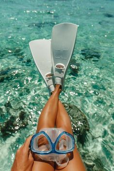 a person laying on their back in the water wearing goggles and snorkels