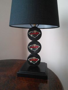 a table lamp with three stones on it and a black shade in the corner behind it