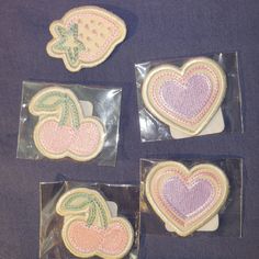 four heart shaped cookies in plastic bags on a table