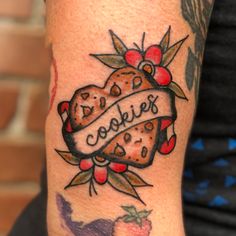 a woman with a tattoo on her arm that says cookies and hearts in the center