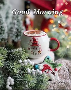 a cup of coffee sitting on top of a table next to some christmas decorations and trees