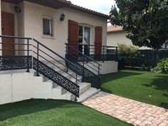 a house that has some stairs in front of it and green grass on the ground