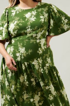 An ethereal floral print takes on a timeless silhouette with a modern taste. The Vetiver Floral print features bright, summer motifs that sit against a green-ground that decorates the Rhythm midi. A dress that features flouncy short sleeves that frame a flattering, fitted bodice that maintains a sleek fit throughout the waist, nearing the hips. A drop waist, asymmetrical skirt sits low on the hips, reminiscent of the twenties and thirties. Wear it with kitten heels and your fave bag.- Drop waist Spring Green Floral Print Midi Dress, Green Floral Print Midi Dress With Short Sleeves, Green Floral Print Short Sleeve Midi Dress, Green Maxi Dress With Floral Print For Garden Party, Spring Green Floral Printed Dress, Spring Green Printed Midi Dress, Flowy Green Printed Floral Dress, Spring Green Floral Print Maxi Dress, Green Printed Flowy Dresses