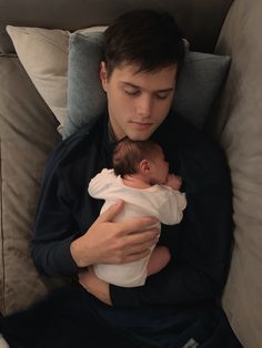 a man holding a baby in his arms