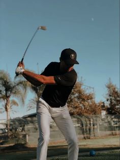 a man swinging a golf club at a ball