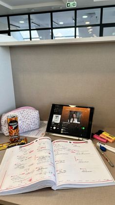 an open book sitting on top of a desk next to a laptop computer