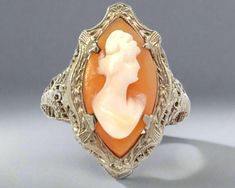 This antique 14K white gold ring boasts exceptional filigree work, a testament to craftsmanship of the past. Own a piece of history and add a touch of elegance to your wardrobe with this timeless piece. Crafted with care, this ring is a must-have for any jewelry collection. Jewelry Style : Ring Metal Type : 14K White Gold  Cameo : Agate and Hand Carved Shell Total Approximate Weight : 3.4 Grams Head of ring measurement : Approximately 25 mm x 15 mm Ring Size : 6.5 : Sizing may be done by your jeweler estate piece, sold as is, all weights are estimates Etsy Gold Ring, Zodiac Pendant, Carved Shell, Jewelry Style, 14k White Gold Ring, Monogram Gifts, Vintage Engagement, White Gold Ring, Vintage Engagement Rings