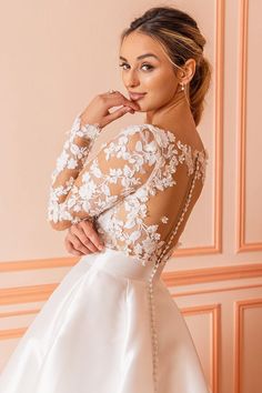 a woman in a wedding dress posing for the camera