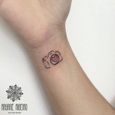 a small wrist tattoo with an elephant holding a heart on it's left arm