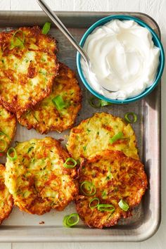 some food that is on a tray and next to a bowl of sour creams