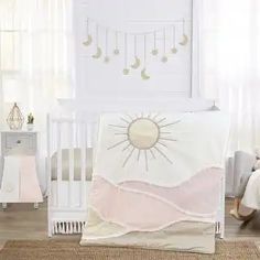 a baby crib bedding set with the sun and moon on it's side