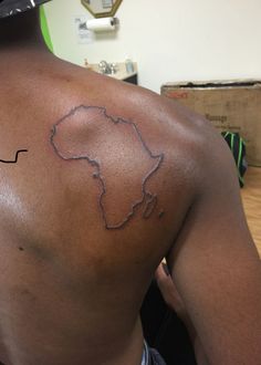 the back of a man's shoulder with a map tattoo on his left side