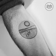 a black and white photo of a man's arm with a tattoo on it