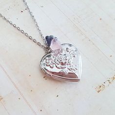 This pretty silver plated locket with palest pink and shimmering grey glass flower beads is suspended from silvr plated chain. Choose your perfect length. It has a beautiful raised rose motif on the front, and is plain on the back. The vintage style locket measures just over 1 1/4 inches (30 mm) across, and opens to reveal space for two photos, or a little secret. The antique silver plated chain has a lobster clasp and extension chain, choose your length from the drop down menu. This locket come Cheap Silver Pendant Locket Necklace, Unique Locket Necklace Silver, Wedding Necklaces With Flower Charm In Metal, Wedding Necklace With Flower Charm In Metal, Metal Pendant Locket Necklace For Wedding, Silver Pendant Crystal Necklace For Mother's Day, Silver Crystal Pendant Necklace For Mother's Day, Mother's Day Silver Pendant Crystal Necklace, Silver Heart Charm Crystal Necklace For Valentine's Day