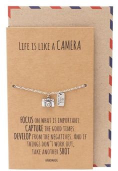 a card with a small camera charm on it's front and the message life is like a camera