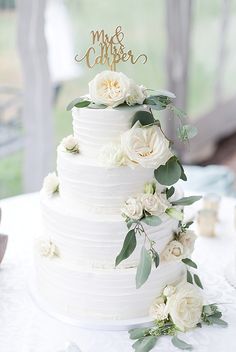 a wedding cake with white flowers and greenery