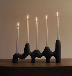 five lit candles are placed in a row on a table