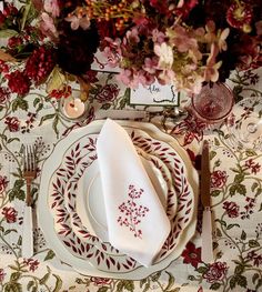 a table set with place settings and flowers