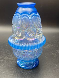 a blue glass vase sitting on top of a table