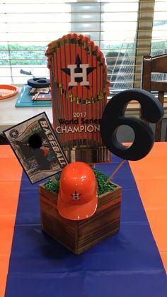 an orange helmet sits on top of a blue table cloth next to a sign that says champion