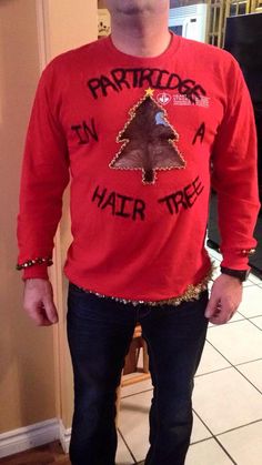 a man standing in front of a mirror wearing a red shirt with an image of a tree on it