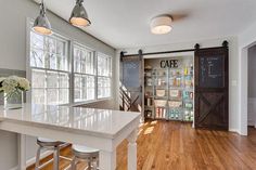 a kitchen with white counter tops and wooden floors