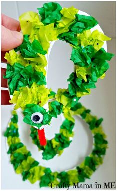 a paper plate wreath made to look like the letter g with green leaves on it