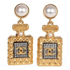 These Chanel Crystal Pearl Perfume Bottle dangle earrings are in gold tone hardware, featuring a gold tone quilted Chanel perfume bottle with faux crystals and the signature CC logo on the front dangling from a small pearl stud earring with post back earring closures.Origin: FranceCondition: New and never wornAccompanied by: Chanel jewelry boxMeasurements: .6" x 1.5" Designer Gold Drop Pearl Earrings, Designer Gold Pearl Drop Earrings, Chanel Perfume Bottle, Dangle Earrings Gold, Preformance Outfits, Chanel Perfume, Chanel Jewelry, Ear Rings, Gold Earrings Dangle